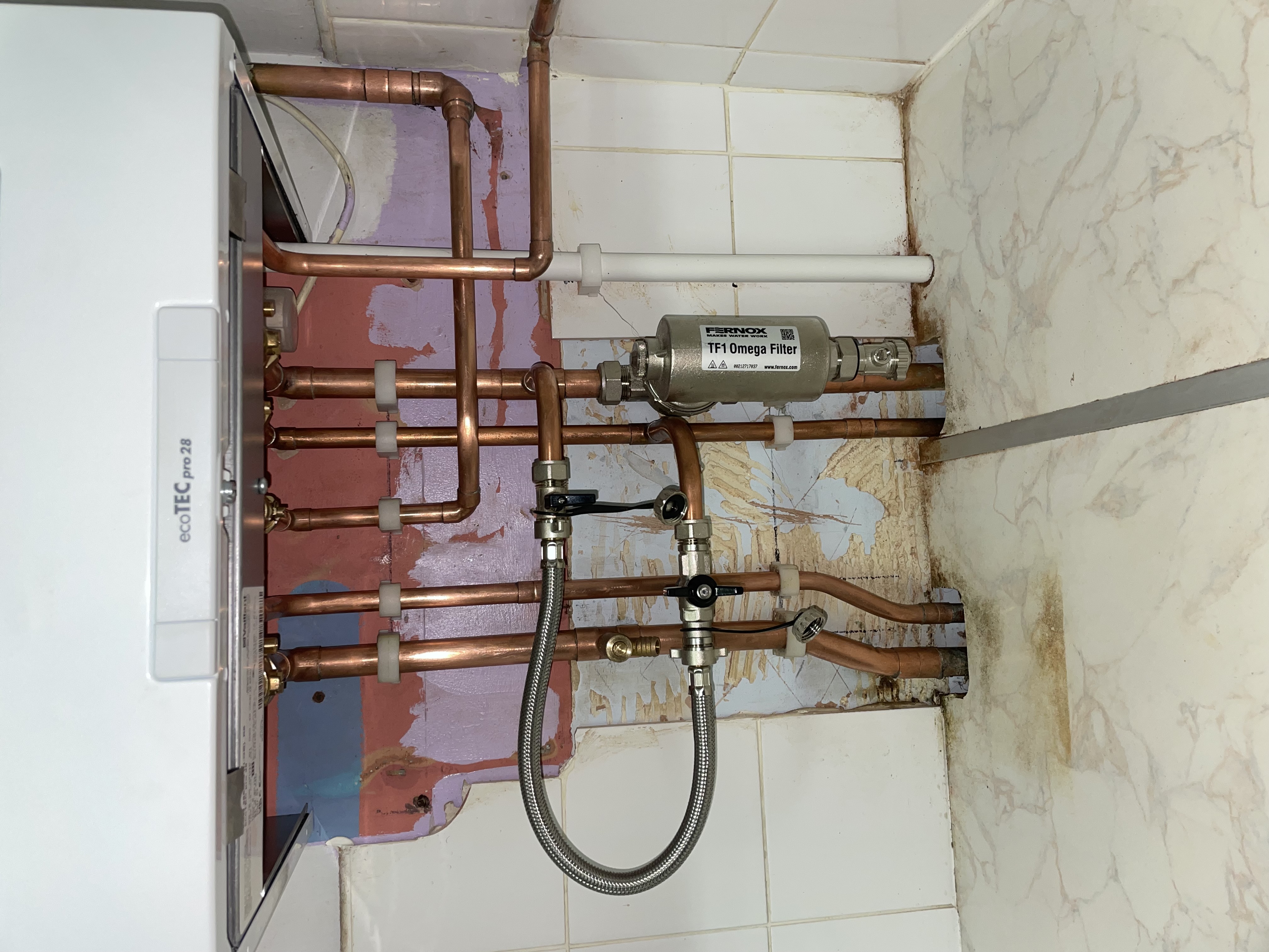 Domestic boiler pipework finished neatly beneath the appliance by Pomona Eco Solutions